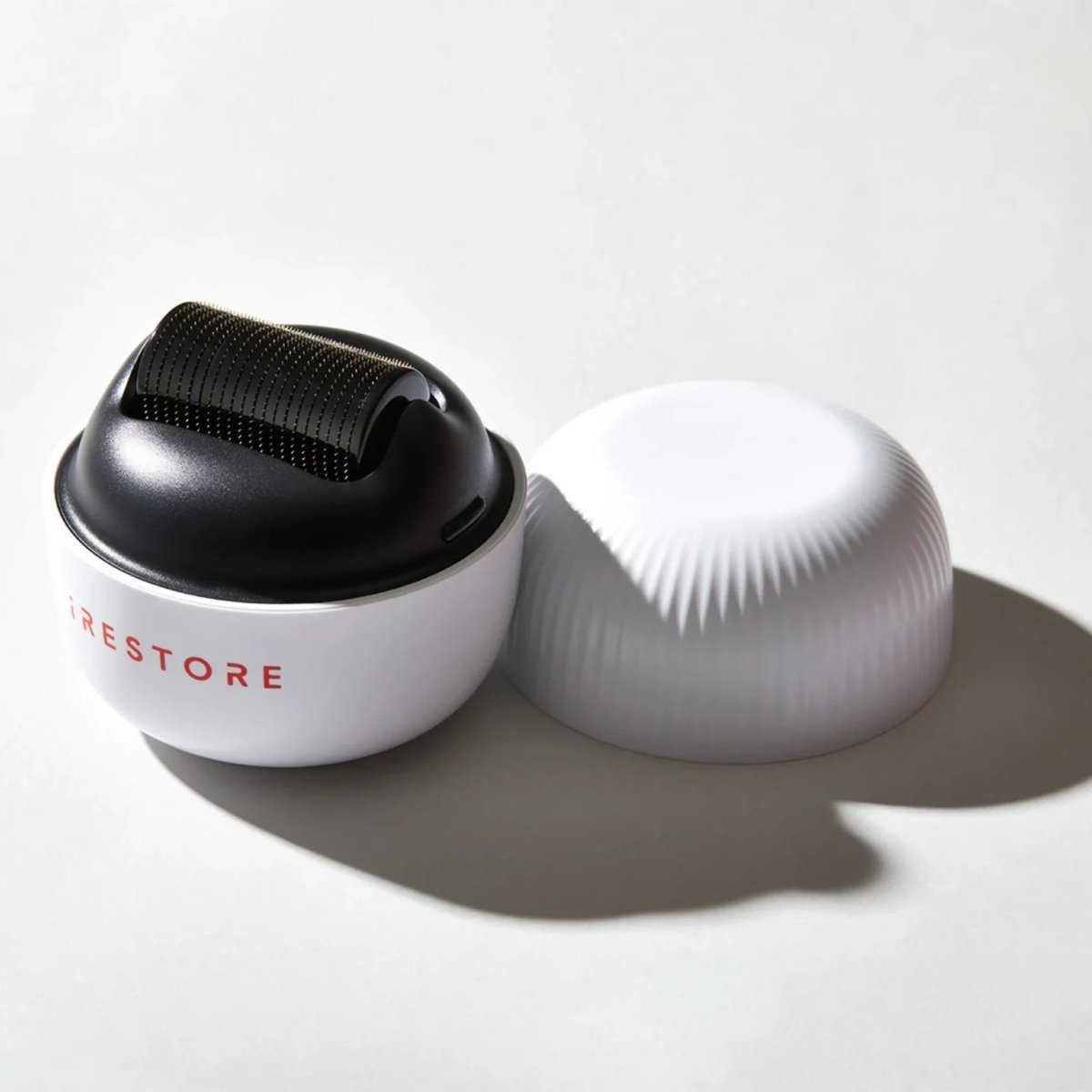 Two iRestore scalp massager devices displayed side by side