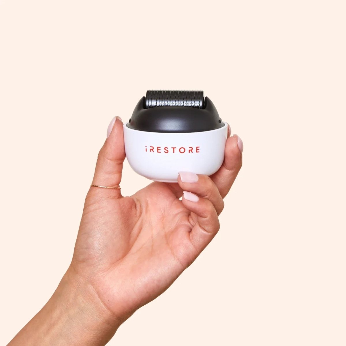 Hand holding iRestore scalp massager for convenient daily scalp care