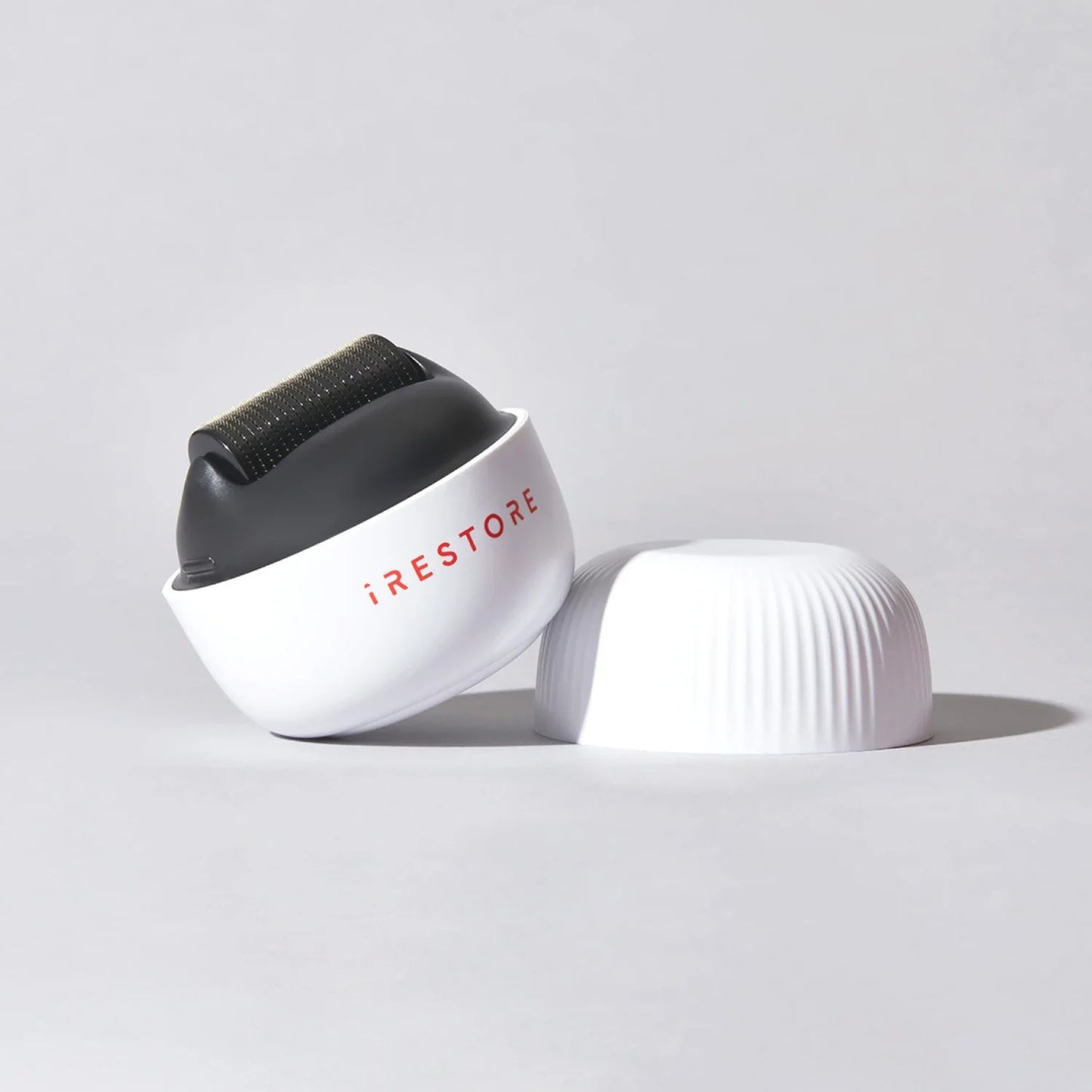 Smiling woman using iRestore scalp massager for stress relief and scalp health