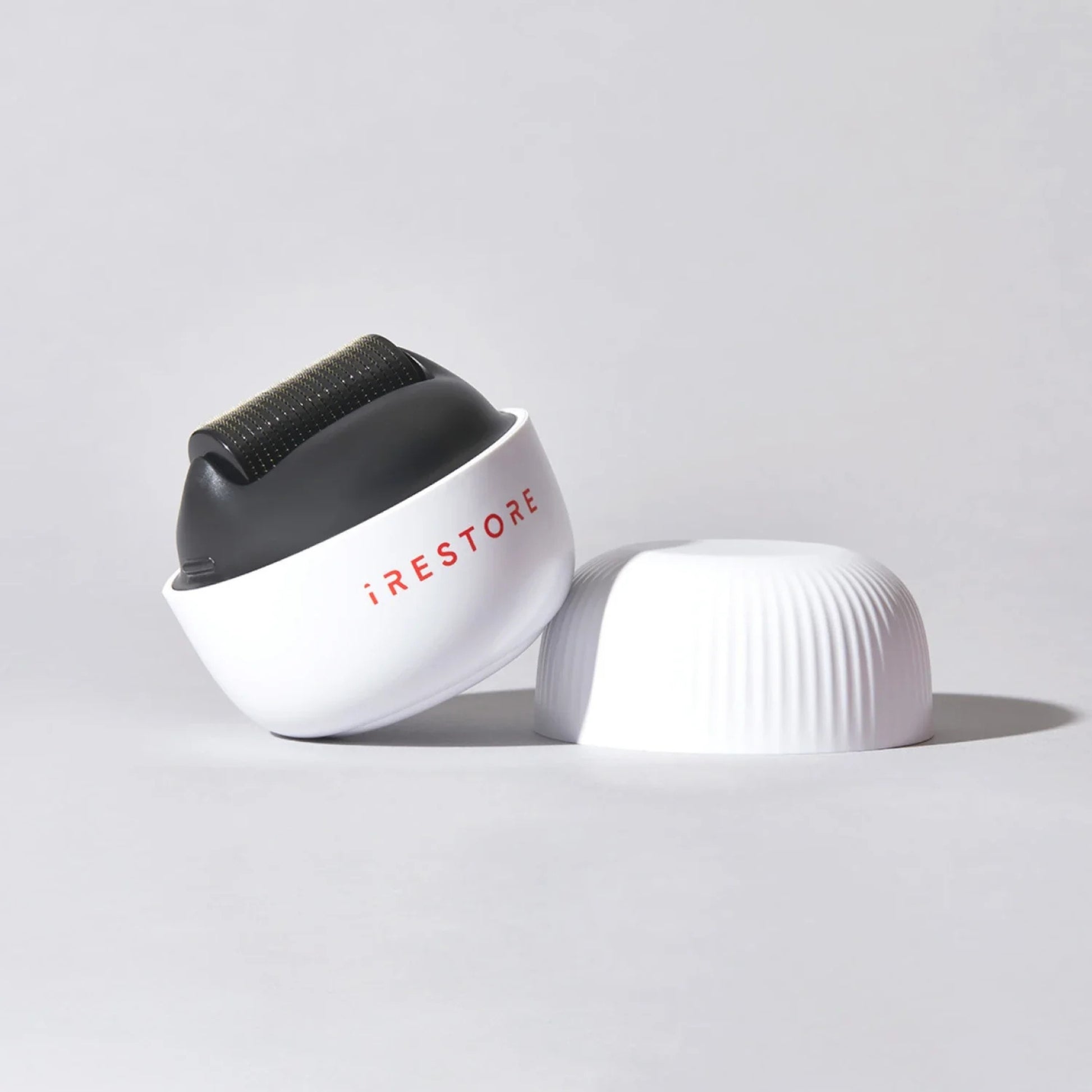 Smiling woman using iRestore scalp massager for stress relief and scalp health