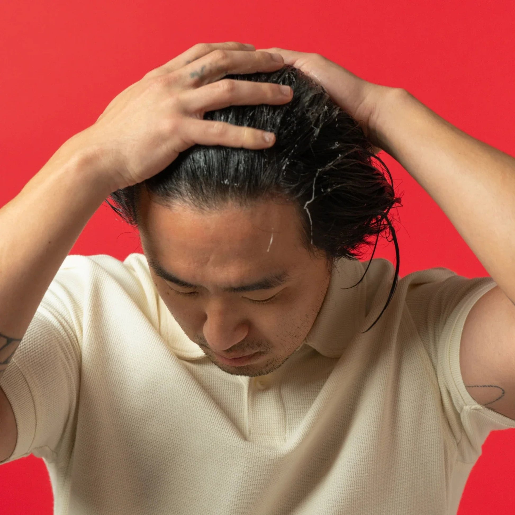 Man applying iRestore Thickening Conditioner during shower hair care routine