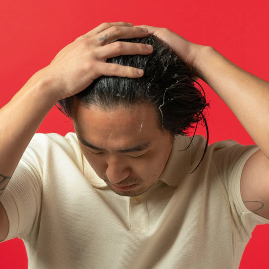 Man applying iRestore Thickening Conditioner during shower hair care routine