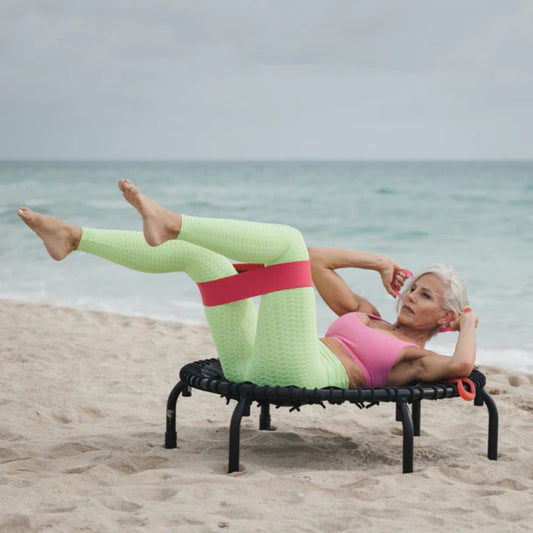 Athlete exercising with Jumpsport resistance bands on beach trampoline