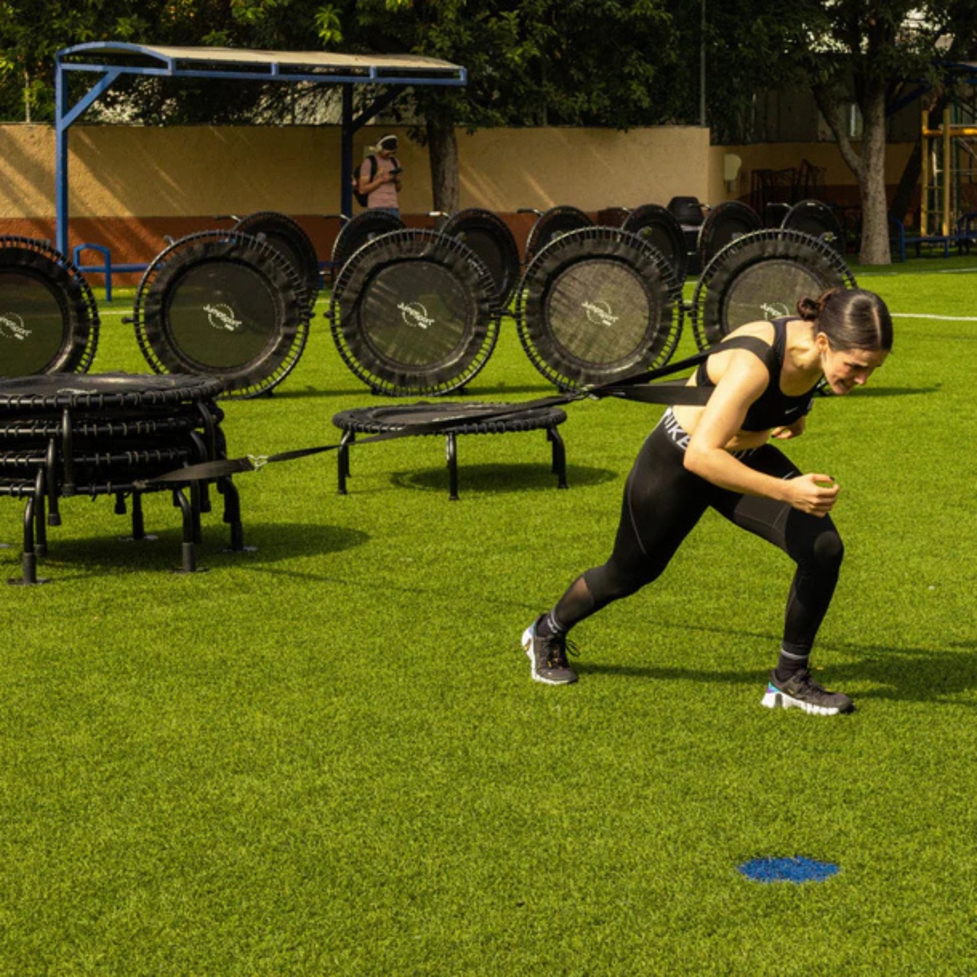 Athlete training outdoors on Jumpsport trampoline with replacement leg set