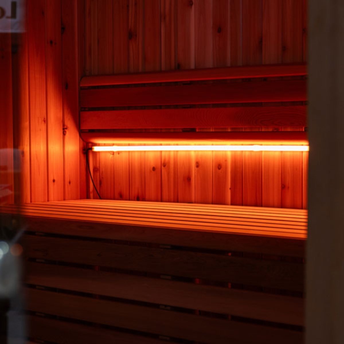 Leisurecraft 46-inch Lighting Set under cedar sauna bench, featuring amber LED lights that create a warm glow in the space.