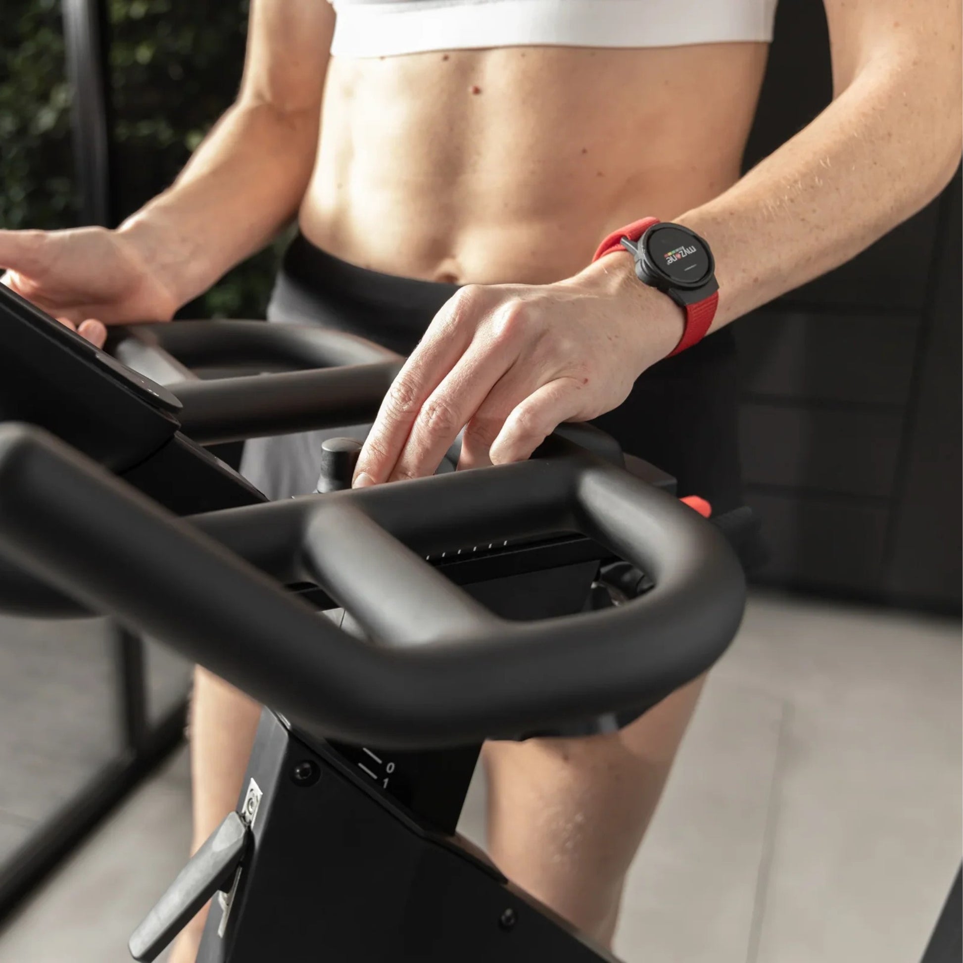 Close-up of Myzone Switch heart rate tracker in use during cycling workout, monitoring heart rate zones in real-time
