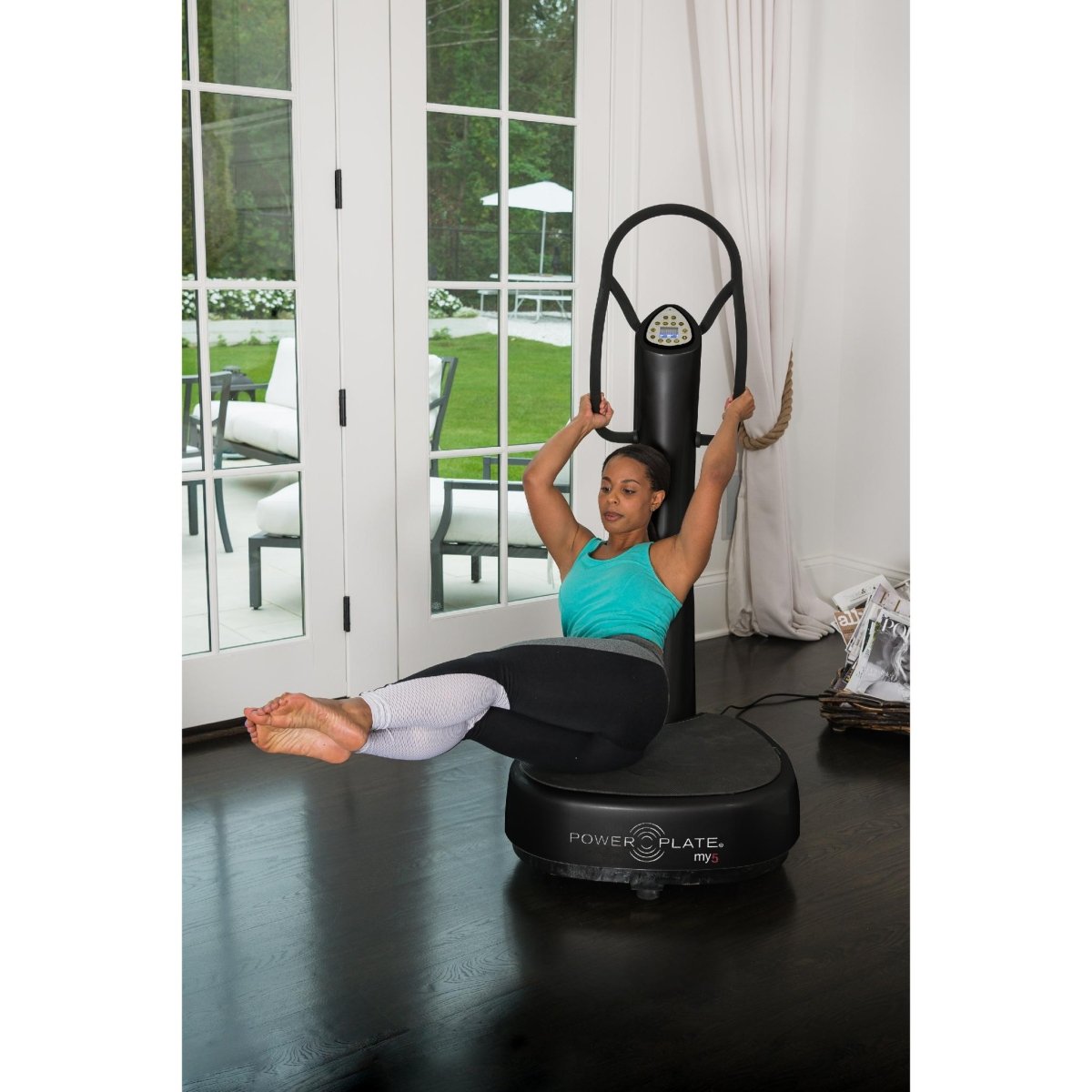 Woman performing a raised leg core exercise on a black Power Plate my5 vibration plate with straight handlebars