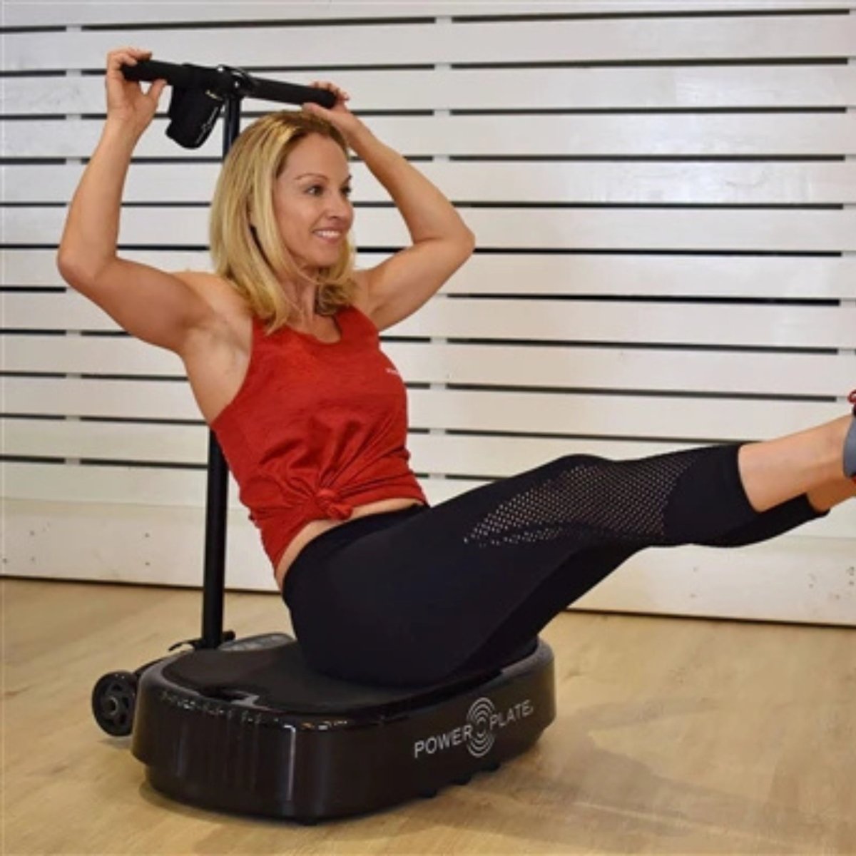 Woman performing core strengthening workout on Power Plate MOVE vibration machine for enhanced muscle engagement