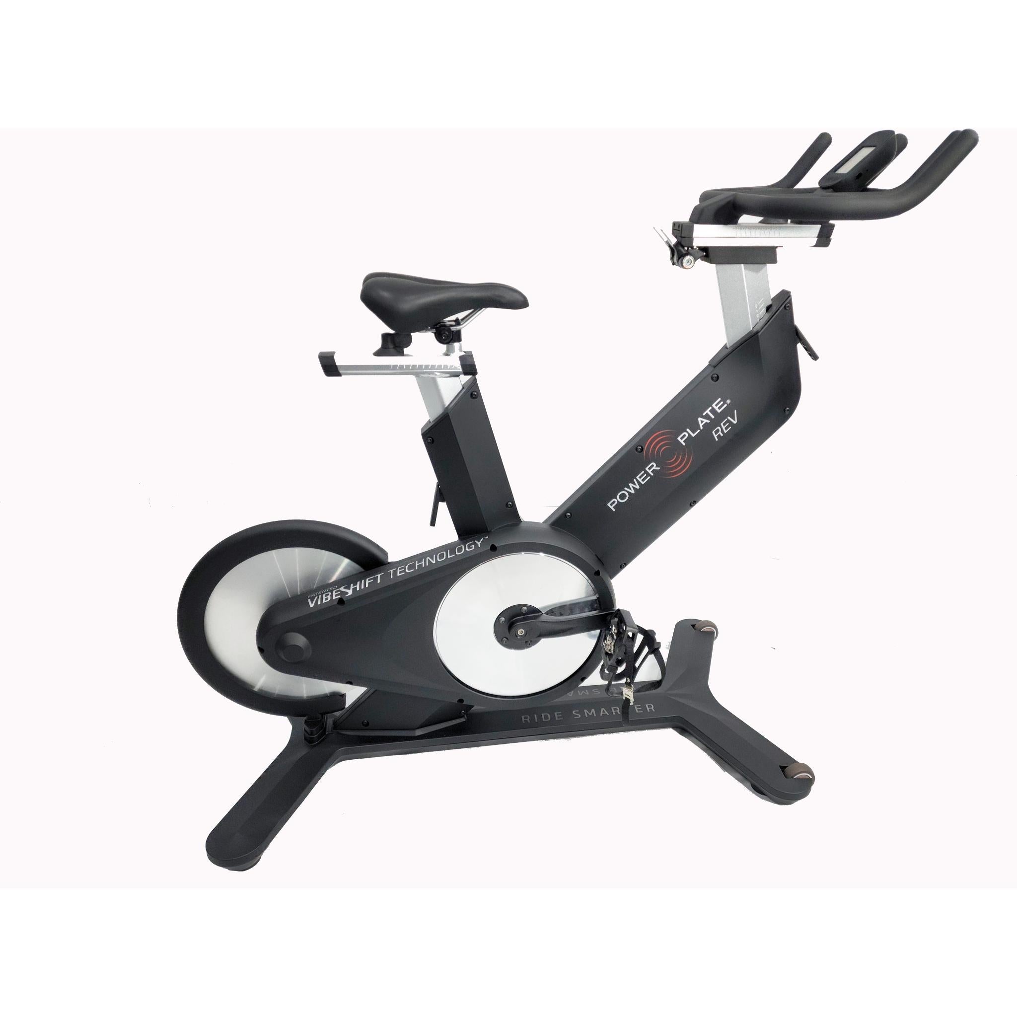 Power Plate REV black vibration training bike with seat, pedals, and handlebars, side view on a white background
