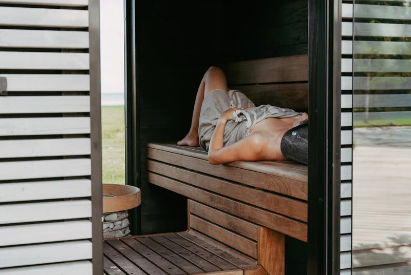 Individual relaxing in an outdoor sauna kit as part of a comfort and balance focused wellness routine and personalized wellness journey.